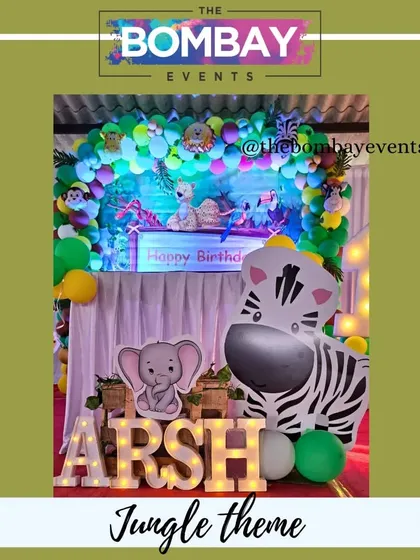 This jungle theme setup for Arsh's first birthday is filled with cute details. The light-up letters spelling his name in front of the stage add a personal and photogenic touch.
