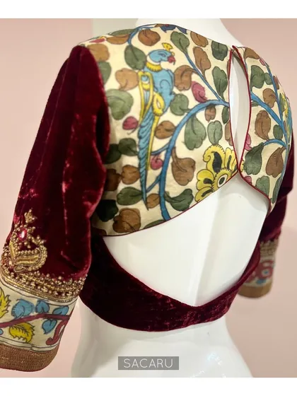 The perfect amalgamation of Indian fabrics and techniques. This blouse features hand-painted Kalamkari fabric and rich maroon velvet, with a keyhole back.