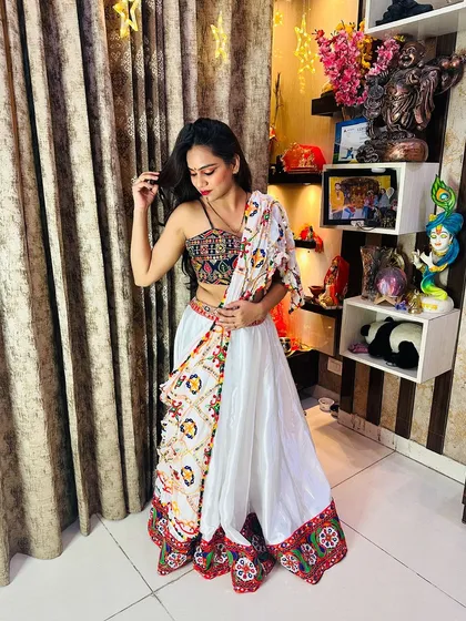 A full shot of the white satin lehenga, showing how the colorful blouse and border pop against the white fabric.