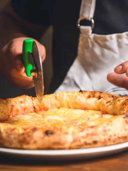 The final cut. Slicing through a perfectly baked Quattro Formaggi, ready to be served.