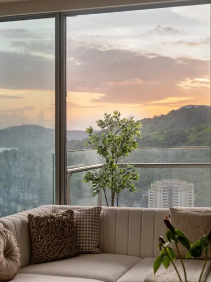 The view from inside, looking out onto a balcony with a stunning sunset over the hills. This shows how a well-styled home can frame and enhance the beauty of its surroundings.
