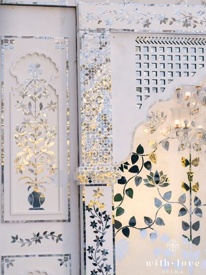 A detailed shot of the Thikri paneling, showing the precision of the hand-cut mirror pieces. This ancient art form brings a unique and luxurious feel to our events.
