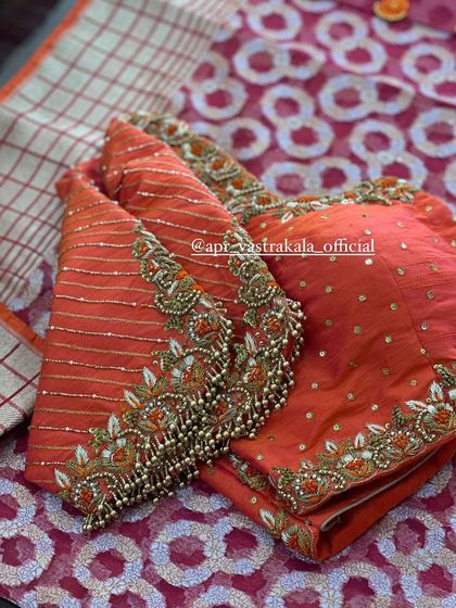 An orange blouse with striped sleeves and heavy floral embroidery.