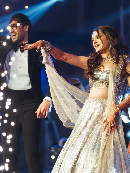 A perfect dance move captured in time. The bride's sparkling lehenga and the stage lights created a beautiful visual as they moved across the floor.