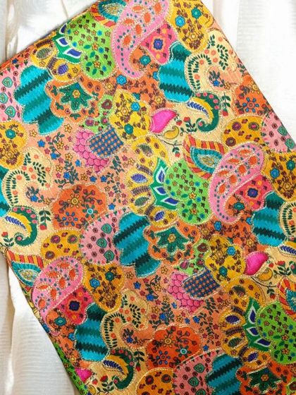 This vibrant, multi-colored printed fabric is a burst of joy, perfect for creating a statement piece.