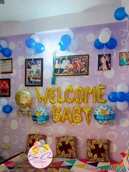 A simple and sweet 'Welcome Baby' boy setup at home, with gold foil letters and bunches of blue and white balloons.
