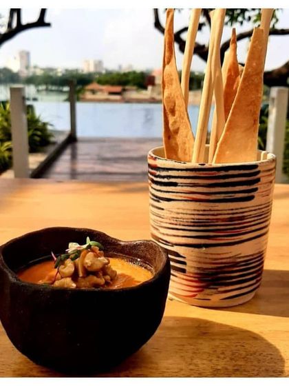 This custom tableware set, featuring a textured bowl and a striped utensil holder, was designed to complement the beautiful lakeside view and gourmet food at Conrad Bengaluru.