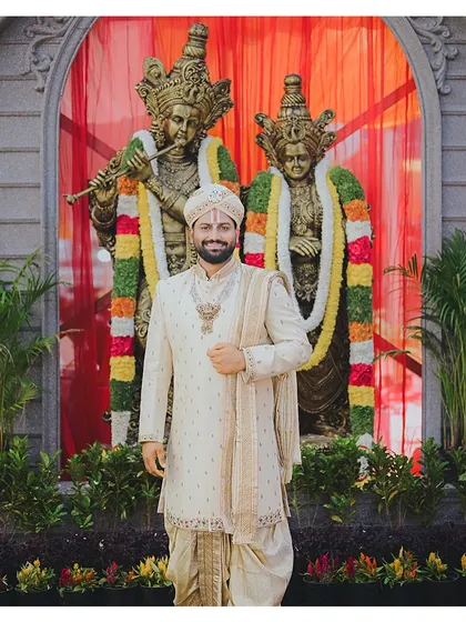 Here is a full view of a bespoke groom's outfit for a traditional South Indian wedding. The look includes a pure silk sherwani with subtle embroidery, a matching dhoti, and a custom wedding turban, creating a regal and elegant presence for the main ceremony.