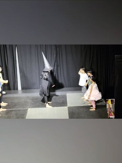A witch character makes her entrance! This photo showcases the children's creativity in costume and character development for their self-produced play.