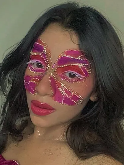 A full-face butterfly mask created almost entirely with rhinestones and glitter. This is an advanced, high-impact look that shows the incredible potential of using gems in your face art.