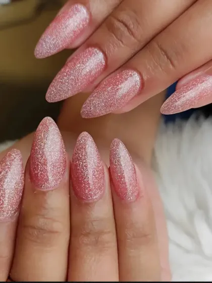 These long almond nails feature a full-coverage, reflective pink glitter polish that catches the light from every angle.