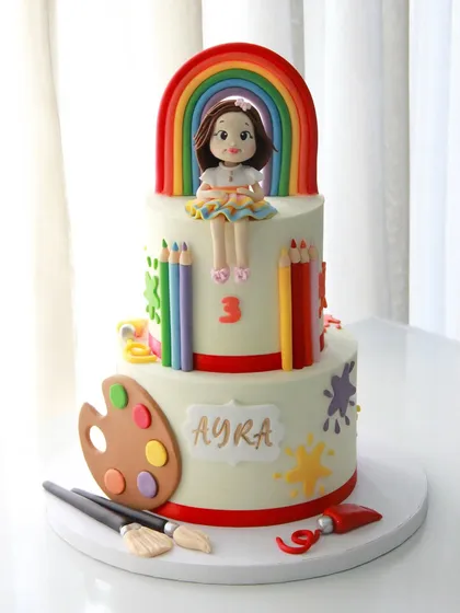 Every child is an artist! This colorful, art-themed cake for Ayra's 3rd birthday features a rainbow, paint palette, brushes, and colored pencils, all made from fondant.