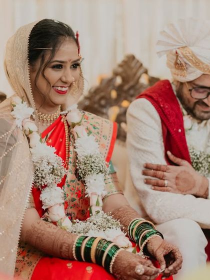 A candid shot of the bride and groom sharing a smile during their wedding ceremony, surrounded by family.