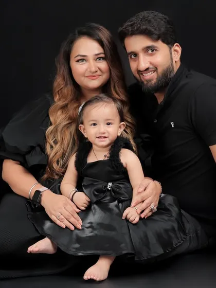 Our classic and dramatic portrait style uses a solid black backdrop to create a striking, intimate feel. By eliminating distractions, the focus is entirely on the family's bond. The coordinated all-black outfits enhance the timeless and elegant mood of this family photo.