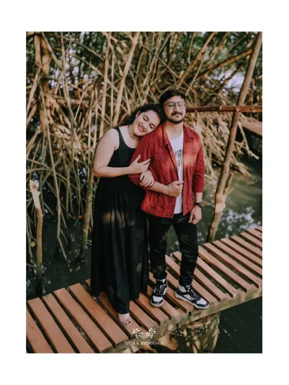 A sweet portrait of the couple on a narrow wooden path, surrounded by the unique beauty of a mangrove forest.
