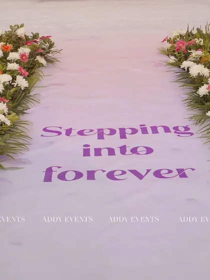 The path to a new beginning. This wedding aisle is lined with fresh flowers and features a custom "Stepping into forever" message, adding a personal and heartfelt touch to the ceremony.
