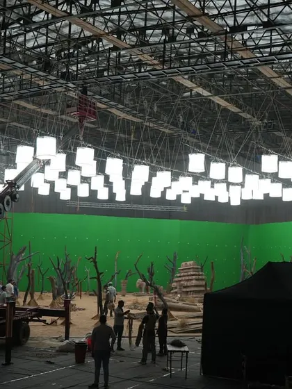 A wide shot of the Coca-Cola set, showing the large-scale rigging and the even illumination provided on the green screen for clean keying in post-production.