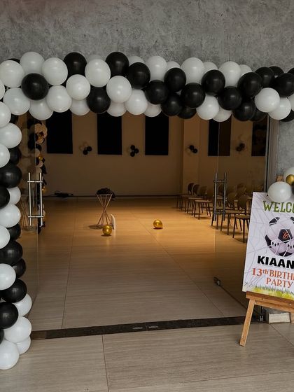 A clean and modern entrance for a football-themed party. The black and white balloon arch and matching welcome sign create a sleek look.