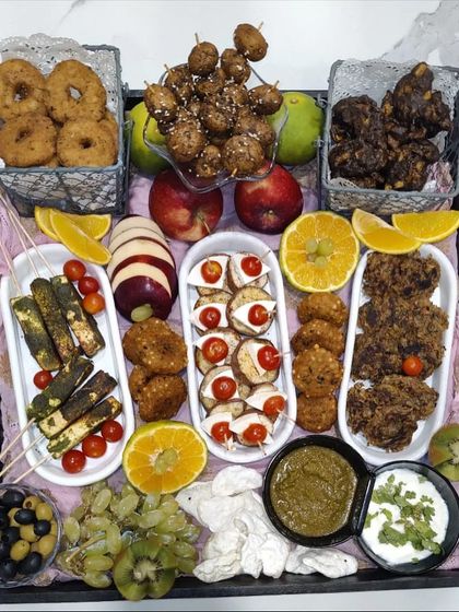 A beautiful and abundant Navratri platter, perfect for sharing. This platter includes a mix of vrat friendly snacks like paneer skewers and fruit chaat, alongside fresh fruits and dips.