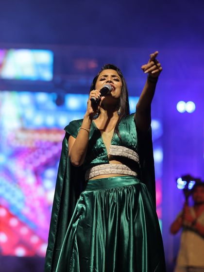 A powerful performance shot. The outfit allows for free movement, which is very important for a singer on stage.