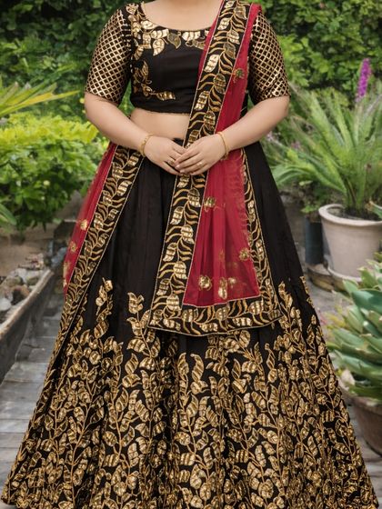 This shot details the heavy gold embroidery that covers the lower half of the lehenga skirt, giving it a luxurious and grand appearance.