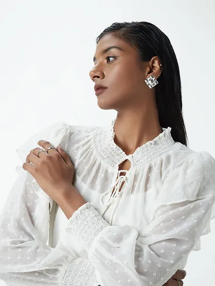 A wet hair look paired with a bold, dark lip for a Westside shoot. This combination creates an edgy, high-fashion vibe that makes the white romantic blouse stand out.