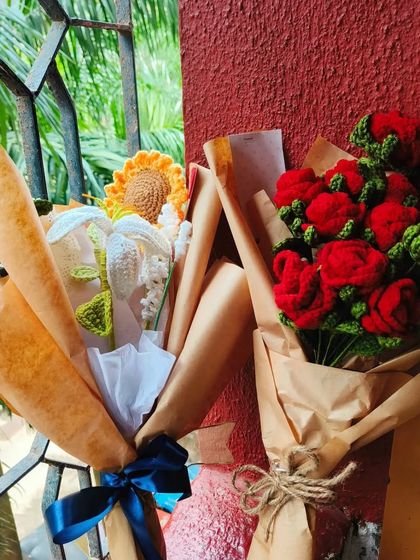Two of my popular bouquets side by side: the sunflower and lily bouquet and the classic all-red rose bouquet. Both are wrapped and ready to go.