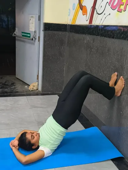 The wall is one of the best yoga props you can find. Here, a student practices a variation of Bridge Pose with her feet on the wall. This provides extra support and allows for a deeper release in the spine and hips.