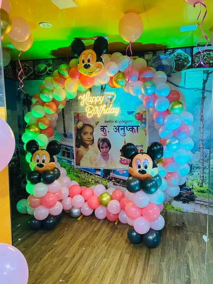 The Mickey Mouse birthday arch under different lighting, highlighting the custom photo banner and neon sign.
