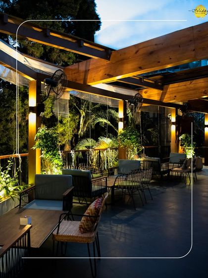 The outdoor seating area at Botanica, our rooftop bar. The warm lighting and lush green surroundings make it an ideal spot for a relaxed evening with drinks and conversation.