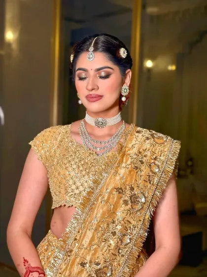 A moment of quiet elegance. The soft lighting enhances the shimmer of the golden outfit and the sparkle of the diamond jewelry.