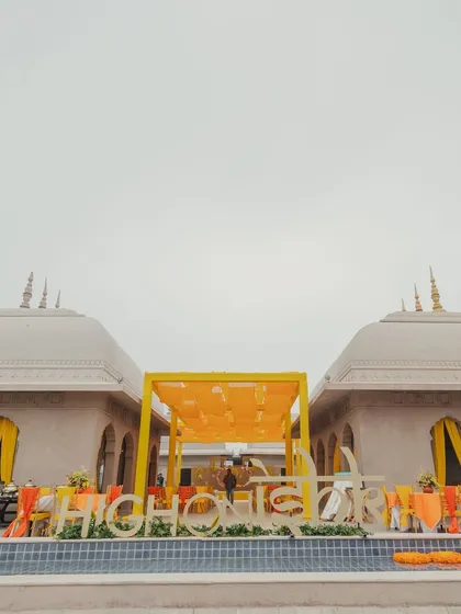 The Haldi setup at Fairmont Jaipur, with a "High on Ishq" sign by the pool, setting a fun and romantic tone for the event.