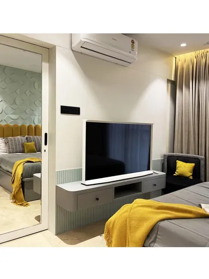 This clever shot uses a full-length mirror to capture both the TV wall and a reflection of the bed's feature wall, showcasing the entire room's cohesive design in one frame.