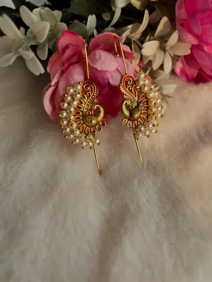 A still shot of the red and gold peacock ear cuffs.