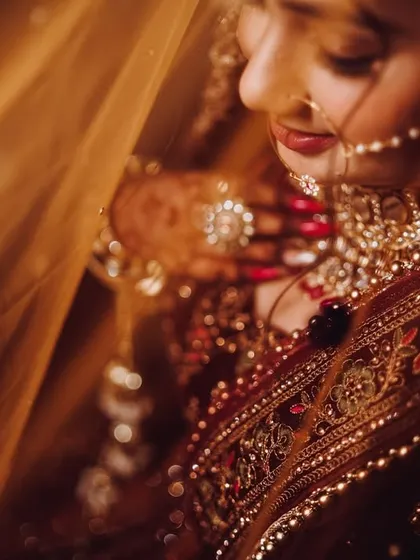 A bride's portrait is a story in itself. Here, we used soft, warm lighting and the delicate veil to create an intimate and serene mood. We focus on capturing the quiet anticipation and the intricate details of the bridal attire and jewelry.