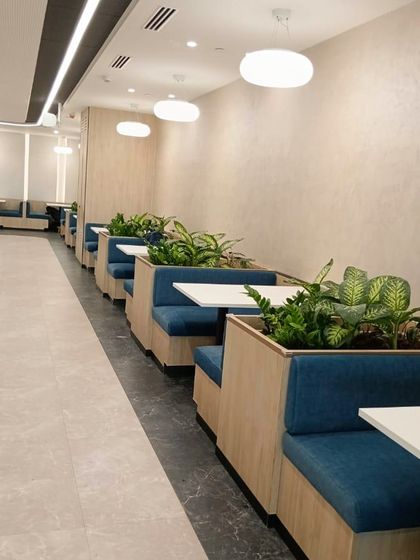 Booth seating in the VeArc cafeteria is made more intimate and inviting with integrated planters. This design creates semi-private spaces for meals and informal meetings.