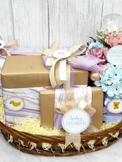 A baby shower basket I created for Varun Dhawan and Natasha Dalal, filled with beautifully wrapped gifts in pastel purples and a stunning floral dome.