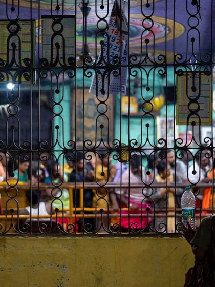 A quiet moment of observation during the pilgrimage. Looking through a gate at the temple, we see the line of devotees waiting patiently. Sometimes, the most profound moments are found not in the center of the action, but in the stillness of watching.