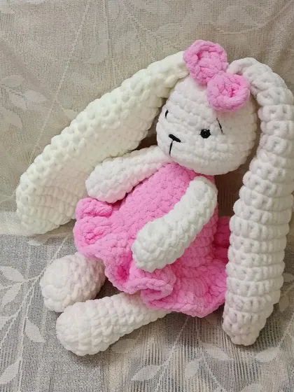 Another pose of the long-eared plush bunny, showing off her adorable pink dress and big, soft ears.