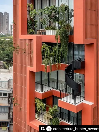 In the dense urban landscape of Mumbai, we sculpted a vertical oasis. This close-up of the Sarvasva tower shows how we integrated cascading greenery and a sculptural spiral staircase, turning the building's facade into a living, breathing garden.
