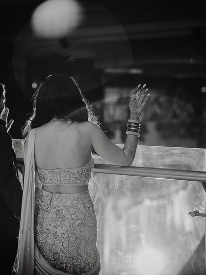 A quiet, cinematic moment of the couple taking a break from the party, looking out at the city lights.