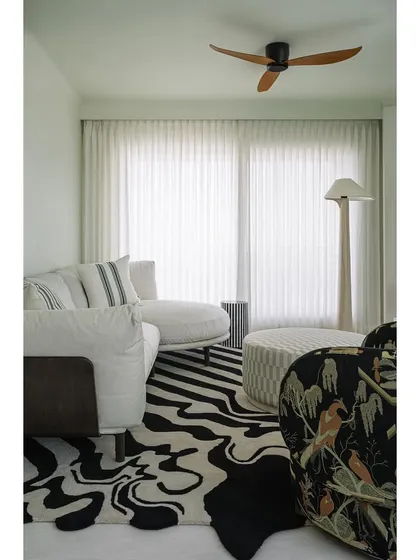The family lounge at Eden House is a cozy retreat. A dramatic black and white carpet, mint green walls, and a countryside-inspired armchair create a space that is both comfortable and full of character.
