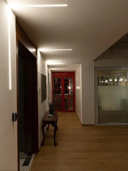 Corridors should not be an afterthought. I used recessed linear lights on the walls and ceiling to create a sense of direction and visual rhythm. This technique also serves as accent lighting, drawing attention to the artwork along the hallway.