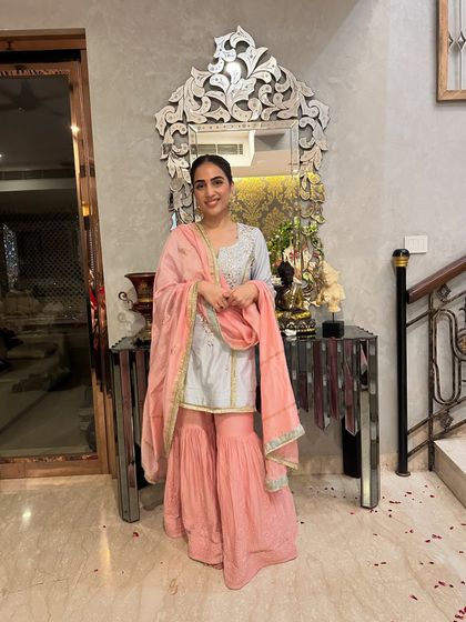 A happy moment during Ganpati celebrations in my blue and pink sharara suit. The joy of the festival is reflected in the bright, cheerful colors of the outfit.