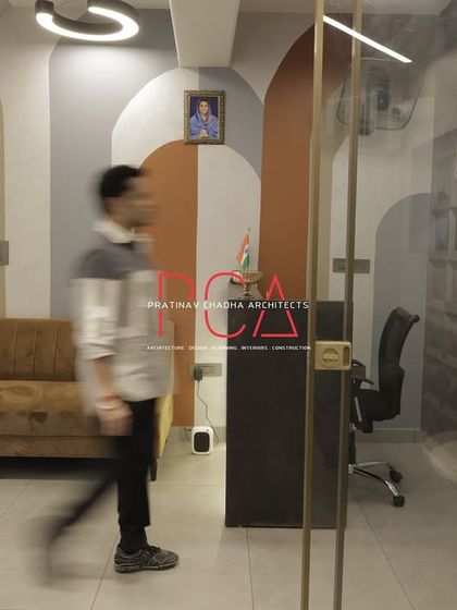 A motion shot capturing the flow of movement through the office, from the reception area past the glass-walled meeting rooms.