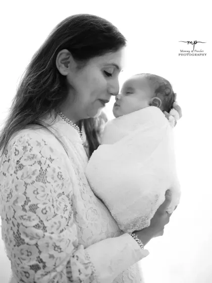 A classic black and white portrait of a mother and her newborn. The monochrome tones emphasize the emotion and timeless beauty of this first embrace.