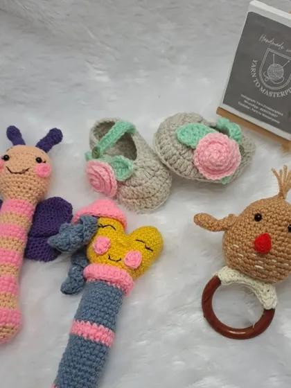 A playful collection of rattles and booties, this gift set includes a variety of stick rattles, a teether rattle, and a pair of rose-adorned booties.