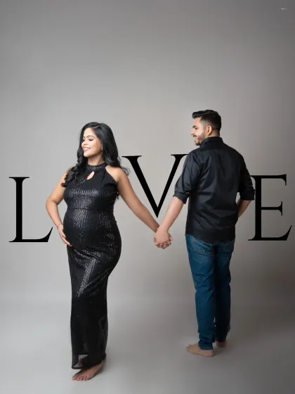 A modern and stylish maternity portrait with a graphic "LOVE" overlay. The couple holds hands, symbolizing their partnership as they step into this new chapter together.