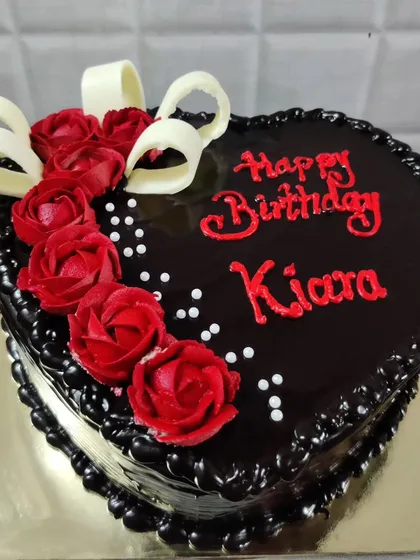 A heart-shaped chocolate birthday cake for Kiara. The rich chocolate glaze is beautifully complemented by red buttercream roses.
