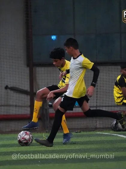 A player shields the ball from a defender, showcasing strength and game awareness.